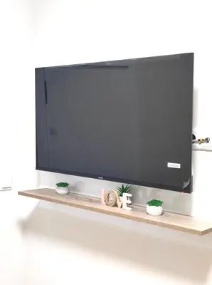a flat screen tv sitting on a shelf with plants at VN Home 2 in Pomorie
