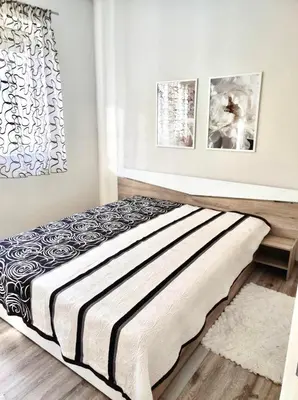 a bed in a bedroom with two pictures on the wall at VN Home 2 in Pomorie