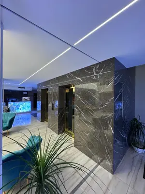 a lobby of a building with a marble wall at Harmony Grand Resort - Apartament Gut in Sunny Beach