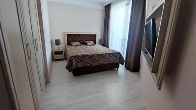 a bedroom with a bed and a flat screen tv at Luxuriöse Ferienwohnung im Harmony Suites Monte Carlo in Sunny Beach