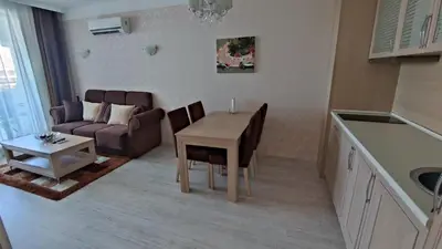 a kitchen and living room with a table and a couch at Luxuriöse Ferienwohnung im Harmony Suites Monte Carlo in Sunny Beach
