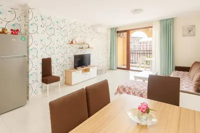 a living room with a kitchen and a dining room at Olymp SkyView Apartment in Sveti Vlas