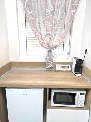 a kitchen with a microwave and a window at VN Home 1 in Pomorie