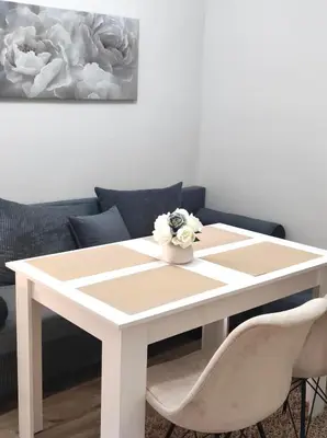 a white table with flowers on it in a living room at VN Home 1 in Pomorie