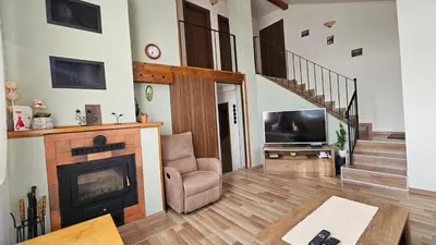 a living room with a fireplace and a television at Къща за гости АВЛИГА in Varna City