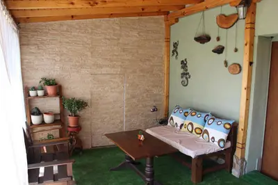 a porch with a bench and a table in a room at Къща за гости АВЛИГА in Varna City
