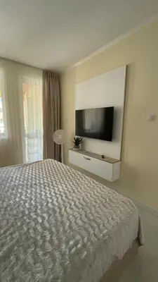 a bedroom with a bed and a flat screen tv at Luxus und Komfort im Vista Residence Komplex in Sveti Vlas