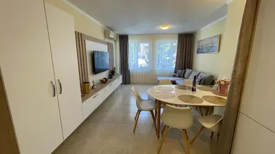 a kitchen and living room with a table and chairs at Luxus und Komfort im Vista Residence Komplex in Sveti Vlas