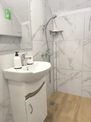 a white bathroom with a sink and a shower at Apartment Compass- Super Center Burgas in Burgas City
