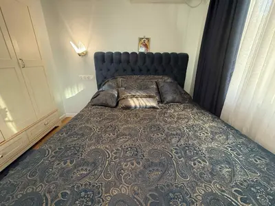 a bedroom with a large bed with a blue head board at Victoria- две спални делукс до Морската градина и центъра in Burgas City