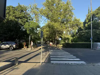 a crosswalk on a city street with people walking down the street at Victoria- две спални делукс до Морската градина и центъра in Burgas City