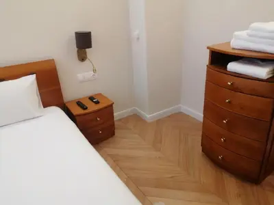 a bedroom with a bed and a dresser at Victoria- две спални делукс до Морската градина и центъра in Burgas City