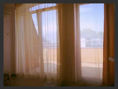 a window with white curtains in a room at Concordia Plaza 2 in Primorsko