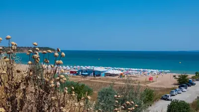 a beach with a bunch of parked cars and the ocean at June Sea view Studio Apartment in Burgas City