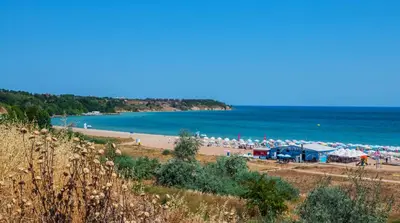 a beach with a bunch of umbrellas and the ocean at June Sea view Studio Apartment in Burgas City