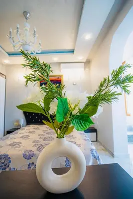 a white vase with white flowers in it on a table at AR Luxury VIP Apartments Ravda in Ravda