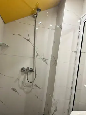 a bathroom with a shower with a glass door at Мансарда in Nesebar