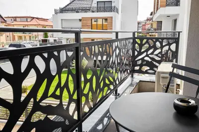 a balcony with a table and a view of a city at Sea Sunrise Apartment Sozopol in Sozopol