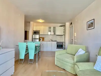 a kitchen and living room with a couch and a table at Prestige Fort Aparthotel - Private apartment - BSR - 1 in Sveti Vlas