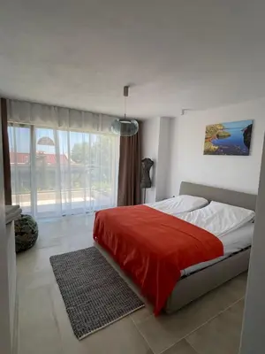 a bedroom with a bed with a red blanket at Dimargo in Lozenets
