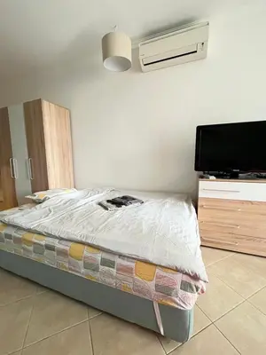 a bedroom with a bed and a flat screen tv at Aquamarine Studio in Santa Marina in Sozopol