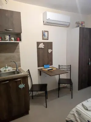 a kitchen with a sink and a table with chairs at Студио в центъра на стария Несебър in Nesebar