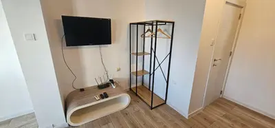 a bathroom with a sink and a tv on the wall at Studio Nikol in Burgas City
