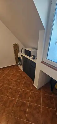 an attic room with a washing machine and a window at Studio Nikol in Burgas City