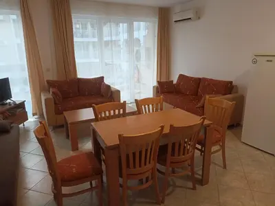 a living room with a table and chairs and a couch at SilverSprings Lucie in Sunny Beach