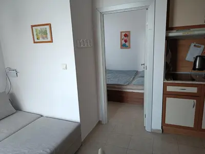 a small bedroom with a bed and a mirror at Sunny Beach Apartment, Kokiche Hotel - white building Liliya in Sunny Beach