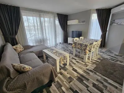 a living room with a couch and a table at Denevi' seaside apartment - 2 bedrooms in Lozenets