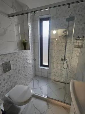 a bathroom with a shower with a toilet and a sink at Denevi' seaside apartment - 2 bedrooms in Lozenets