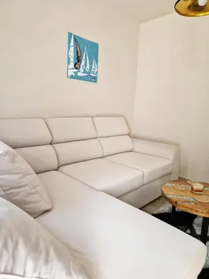 a living room with a white couch and a table at Delux Apart Vulchevi with Parking in Burgas City