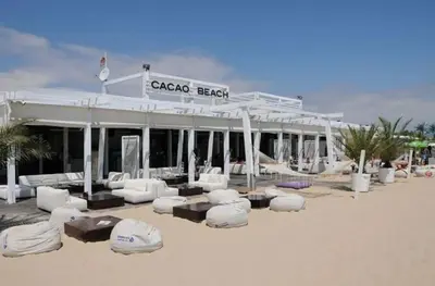 a hotel on the beach with white furniture in front of it at Messembria Resort in Nesebar
