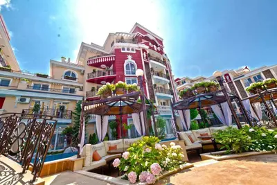 a building with chairs and flowers in front of it at Messembria Resort in Nesebar
