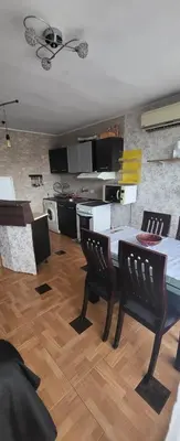 a living room with a table and chairs and a kitchen at Unique Apartment with Balcony in Pomorie Old Town by Flat Mаnаger in Pomorie