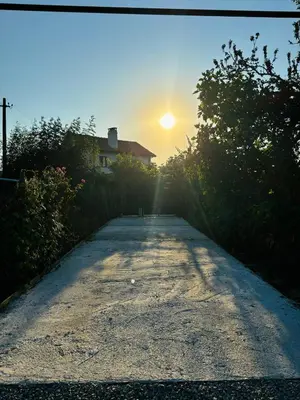 a road leading to a house with the sun setting at Вила 50 in Atiya
