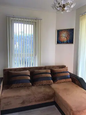 a brown couch in a living room with a window at Ssenyange Sea View Apartment in Varna City