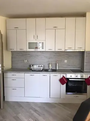 a kitchen with white cabinets and a sink at Ssenyange Sea View Apartment in Varna City