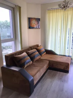 a brown couch in a living room with a window at Ssenyange Sea View Apartment in Varna City