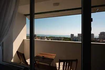 a balcony with a table and a view of the city at Lazur Sea View in Burgas City