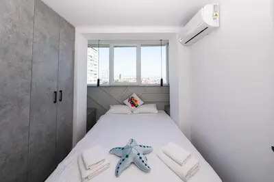 a small bedroom with a bed with a starfish on it at Lazur Sea View in Burgas City
