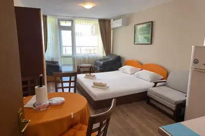 a small hotel room with a bed and a table at Studiosaltsea in Pomorie