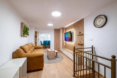 a living room with a couch and a clock on the wall at Angel Home 2bdrm Modern Apartment in Varna City