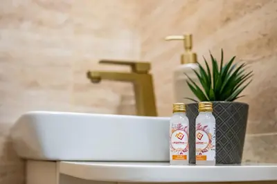 two bottles of beer sitting on a bathroom sink at Angel Home 2bdrm Modern Apartment in Varna City