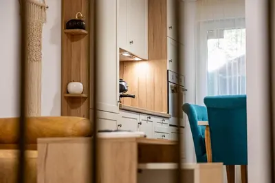 a kitchen with a blue chair and a mirror at Angel Home 2bdrm Modern Apartment in Varna City