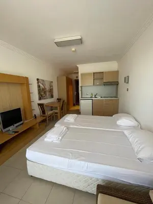 a large bedroom with two beds and a kitchen at Private apartments Ravda-Emerald in Ravda