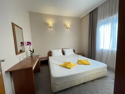 a hotel room with a bed with yellow towels on it at Alatoni Beach Hotel in Sozopol