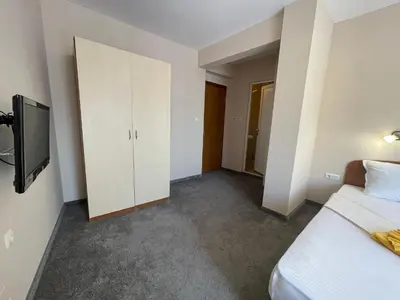 a bedroom with a bed and a tv in it at Alatoni Beach Hotel in Sozopol