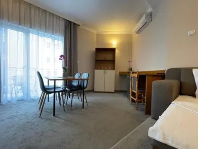 a room with a table and chairs and a bedroom at Alatoni Beach Hotel in Sozopol